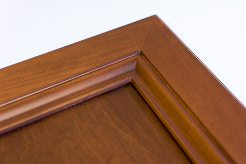 closeup of corner of Anita cabinet door finished in Heritage Walnut (brown tone) stain